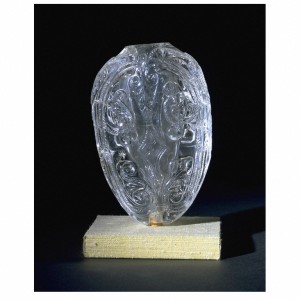 This piece was made between 1000 and 1050. This fine rock crystal piece appears to have been a container. Its complex shape can be seen as the body of a fish. Two convex faces are joined at an angle along the sides, which taper gently towards the base, or tail. However, the fish shape does not continue at the top, where the angled sides broaden out into shoulders. At the centre, these form a collar around the mouth of the hollowed out interior. Another hole was later drilled into the bottom to allow for a mount. 